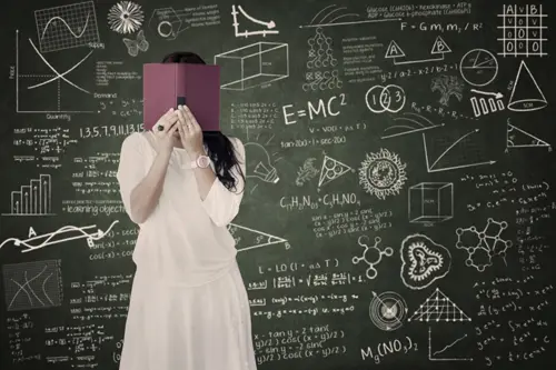 Student hiding behind book